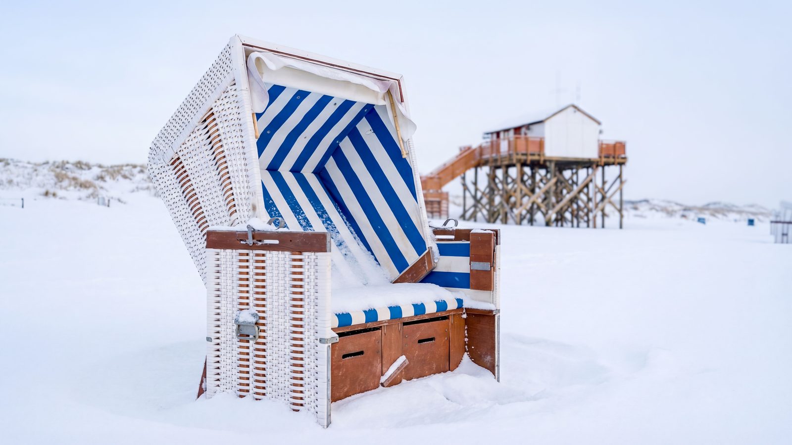 Silvesterurlaub mit Hund: Winterstrand in Sankt Peter-Ording mit Pfahlbauten und Spaziergängern